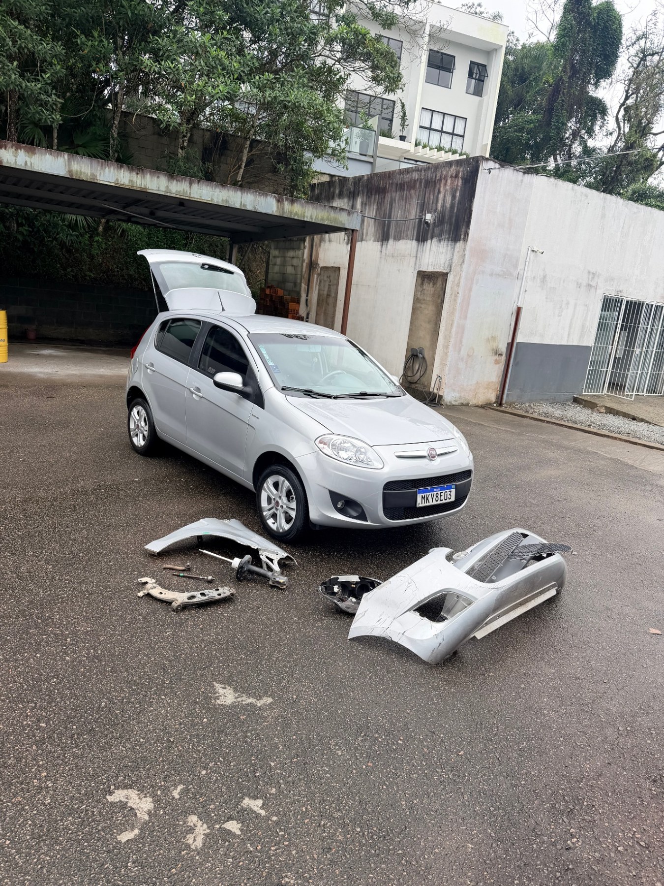 Fiat Palio prata montado após o reparo, com as peças substituídas à frente