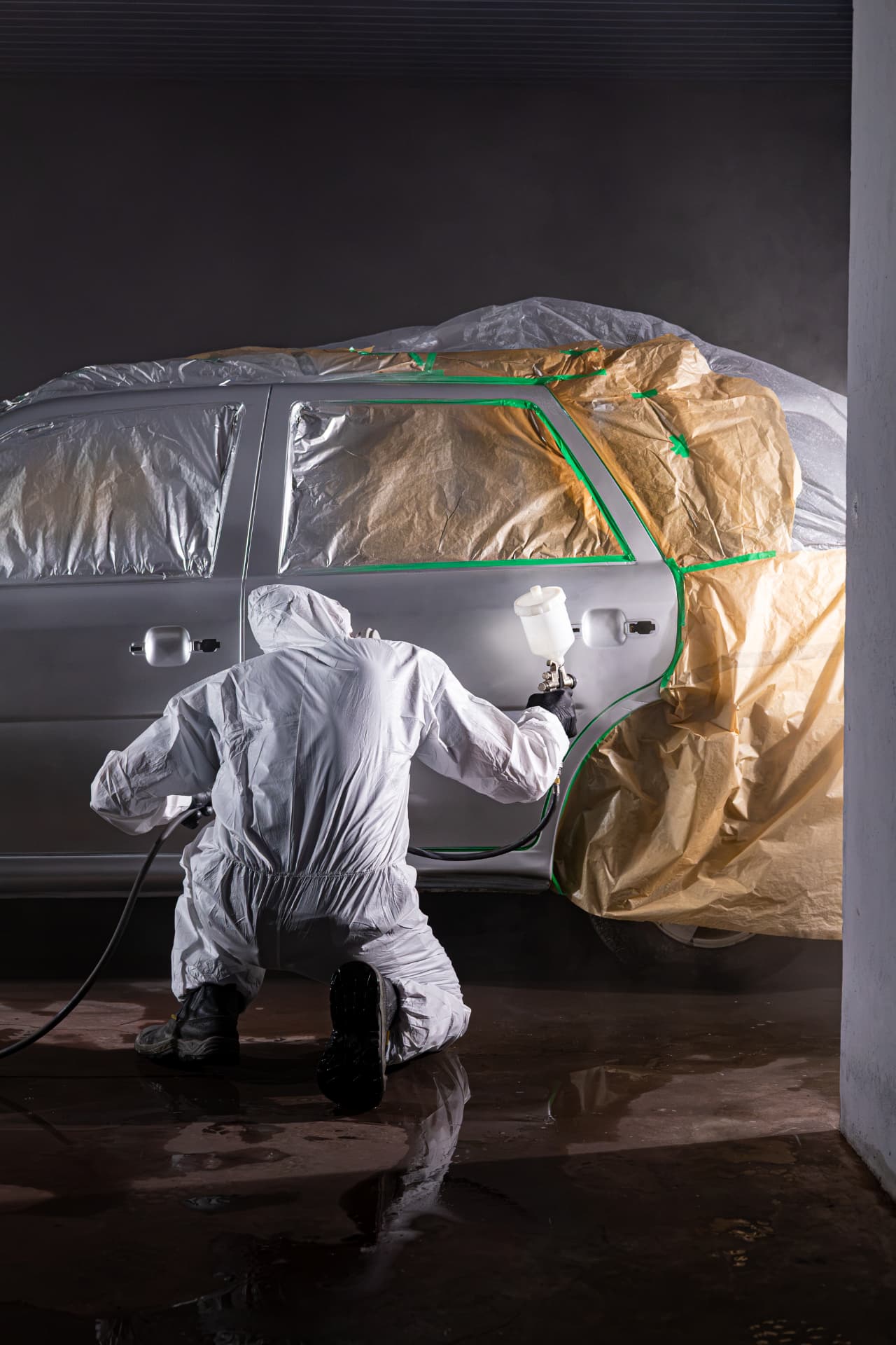 Pintor aplicando pintura em um veículo na oficina da FastBlu Automotiva em Blumenau